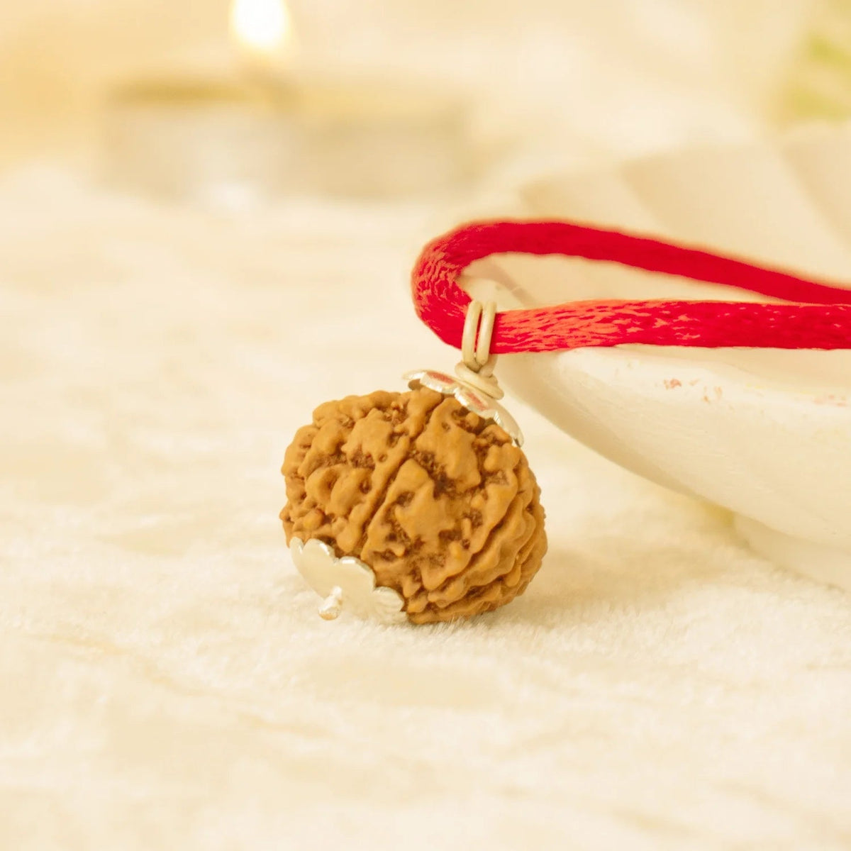 VASTUKOSHA 7 Mukhi Nepal Rudraksha bead pendant on a red thread, blessed at Haridwar for spiritual practice.