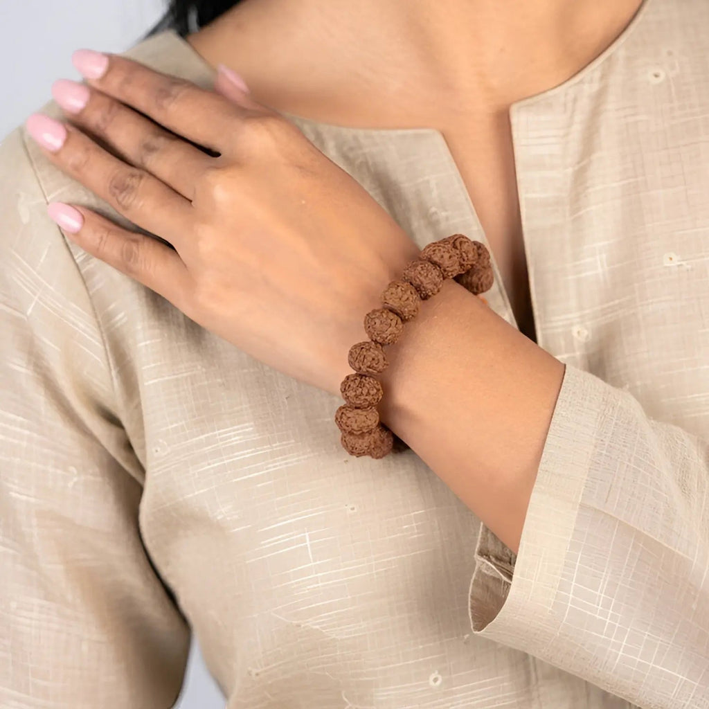 VASTUKOSHA 7 Mukhi Rudraksha bead bracelet worn on a woman's wrist, featuring natural brown textured spiritual beads.