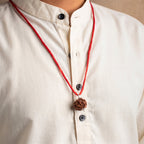 VASTUKOSHA 7 Mukhi Nepal origin Rudraksha bead pendant on a red thread worn against a cream-colored kurta