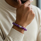 VASTUKOSHA natural 8mm amethyst bead bracelet with a silver Buddha charm worn on a man's wrist.