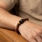VASTUKOSHA Aries zodiac bracelet featuring red jasper and tiger eye beads on a man's wrist.