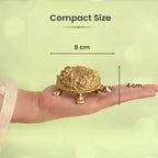 VASTUKOSHA gold-toned Ashtalakshmi tortoise idol held in a hand, showing 8cm by 4cm compact size for Vastu decor.