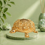 VASTUKOSHA Rinmukteshwar Siddh Ashtalakshmi tortoise idol in gold finish, placed on a cloth with flowers and diya.