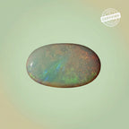 VASTUKOSHA Australian fire opal gemstone with natural play-of-colour, oval-cut, against a light background.