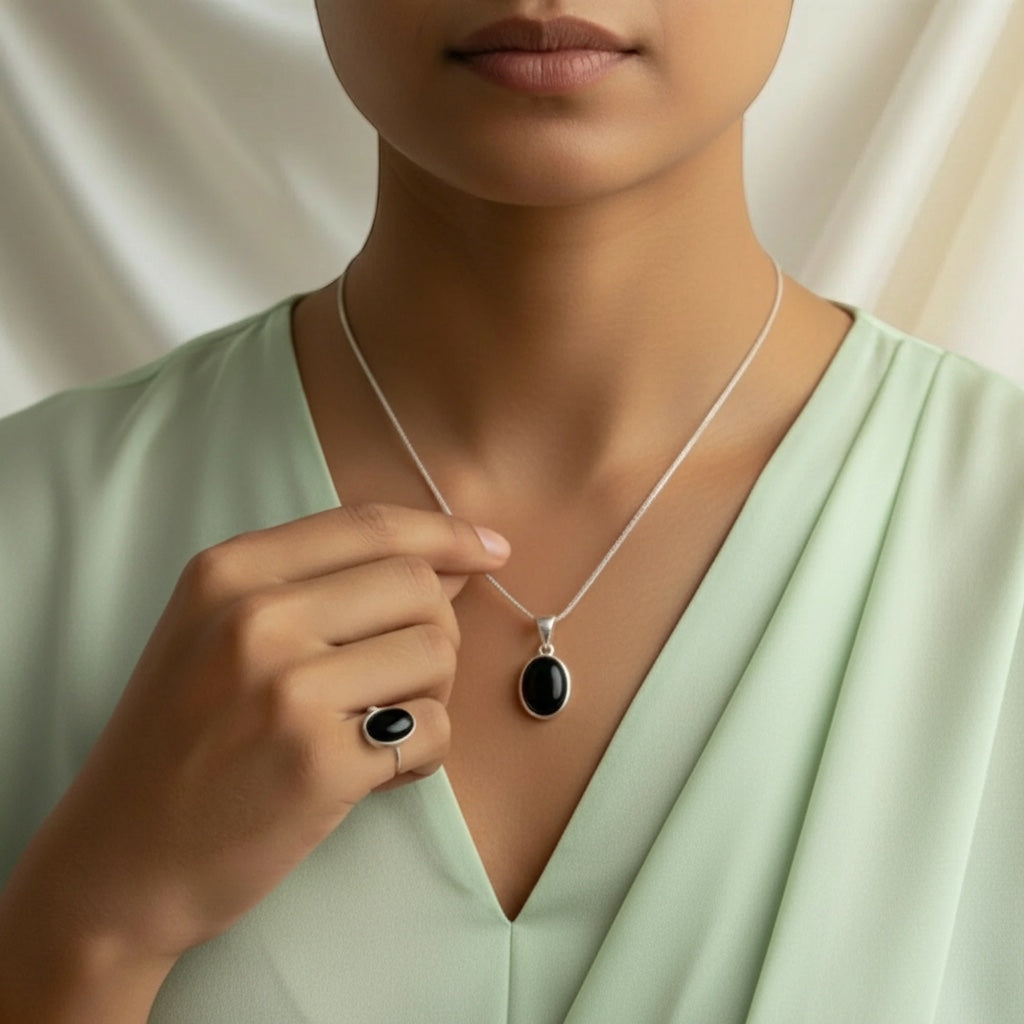VASTUKOSHA natural black agate oval pendant and matching ring set worn by a woman in a light green top
