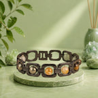 VASTUKOSHA Rishikesh Siddh Dhan Yog bracelet with black metal links and multi-colored healing crystals on fabric.