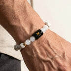 VASTUKOSHA Cancer zodiac bracelet featuring white Howlite and Milky Quartz beads with a black Cancer sign charm on a wrist