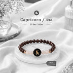VASTUKOSHA Capricorn zodiac bracelet featuring deep red garnet and milky quartz beads with a central Capricorn charm.