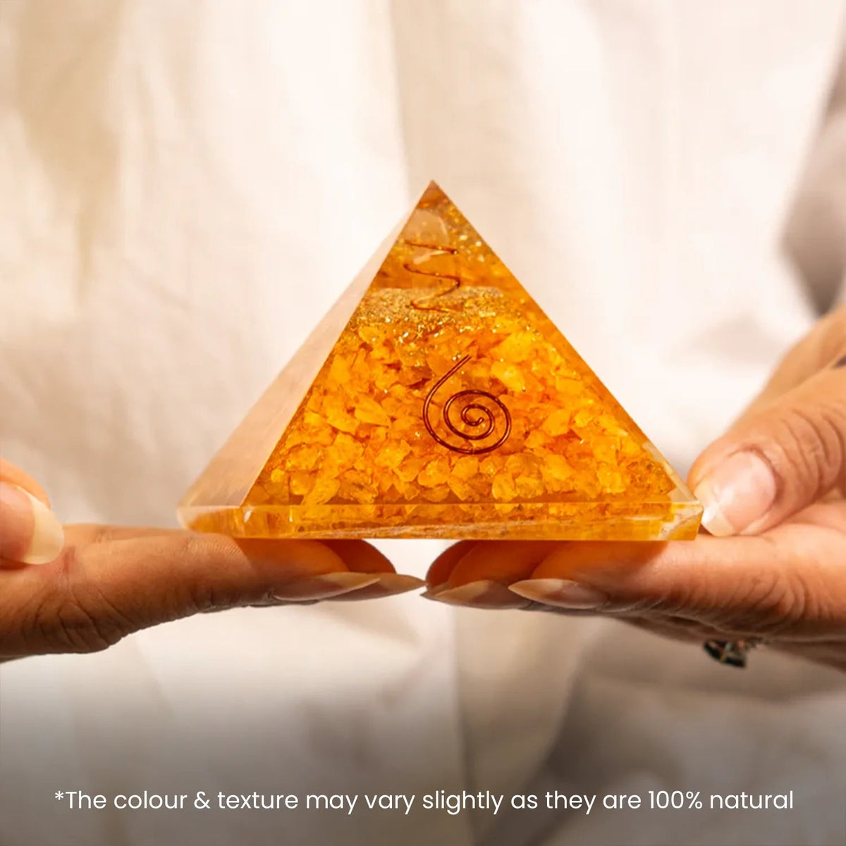 VASTUKOSHA Citrine pyramid with embedded copper spiral held in hands for prosperity and business growth