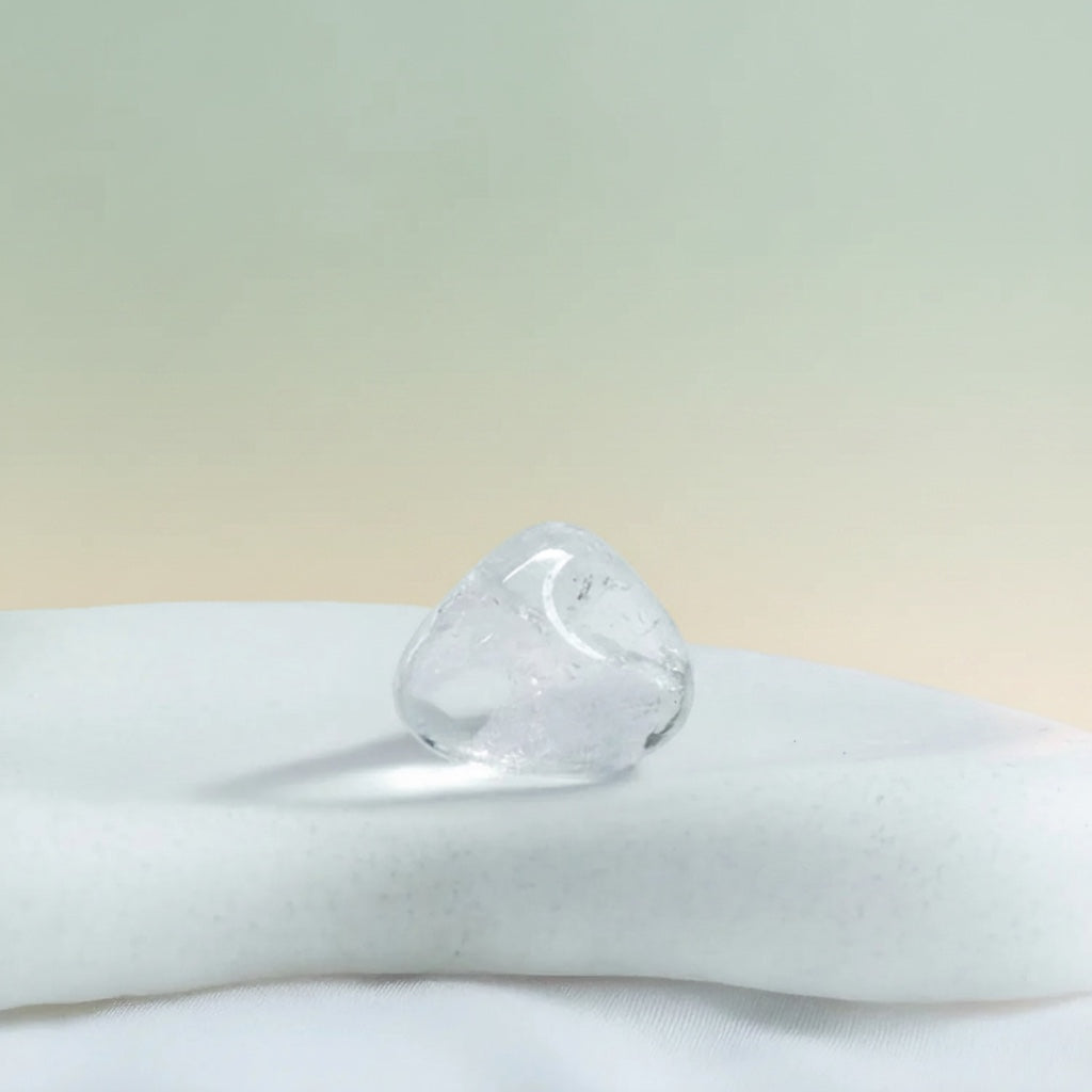 VASTUKOSHA natural clear quartz tumble stone for meditation and spiritual practice on a smooth white surface