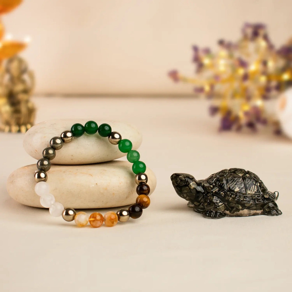 VASTUKOSHA Dhan Yog crystal bead bracelet with multi-colored gemstones and a decorative Pyrite tortoise figurine.