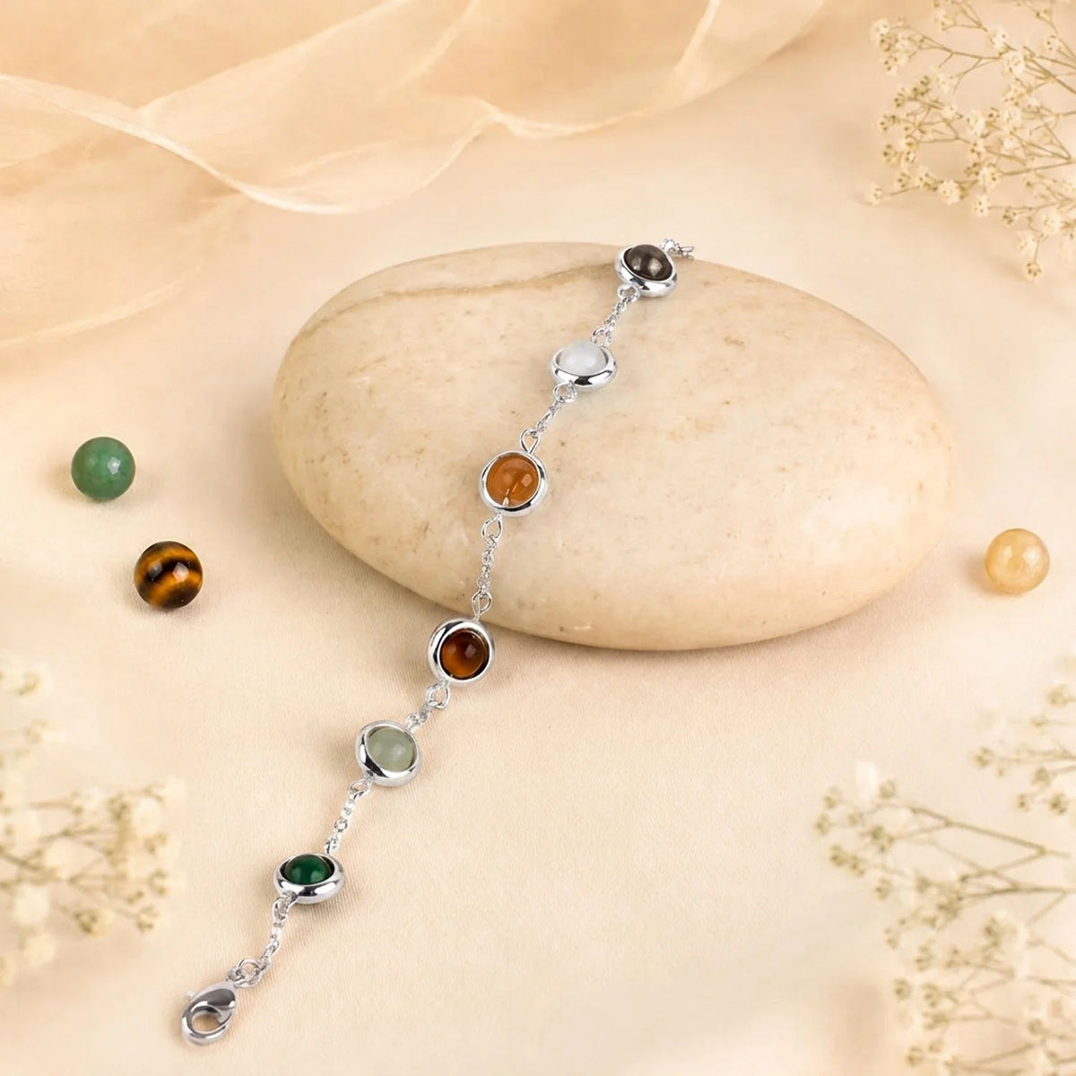 VASTUKOSHA Dhan Yog bracelet featuring multi-colored natural crystals set in a silver-toned brass chain on a stone.