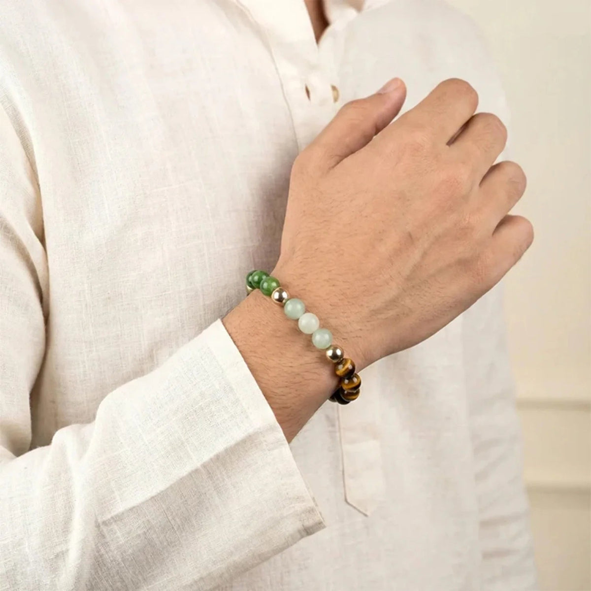 VASTUKOSHA Dhan Yog multi-crystal bracelet featuring tiger eye, pyrite, and green aventurine worn on a man's wrist