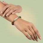 VASTUKOSHA Dhan Yog multi-crystal beaded bracelet worn on a woman's wrist featuring tiger eye and green aventurine