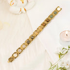 VASTUKOSHA Dhan Yog bracelet featuring genuine crystals in gold-plated metal links on a white surface with a candle.