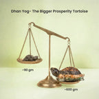 VASTUKOSHA Rishikesh Siddh Dhan Yog Tortoise on a brass scale comparing the 90g and 600g prosperity statues.