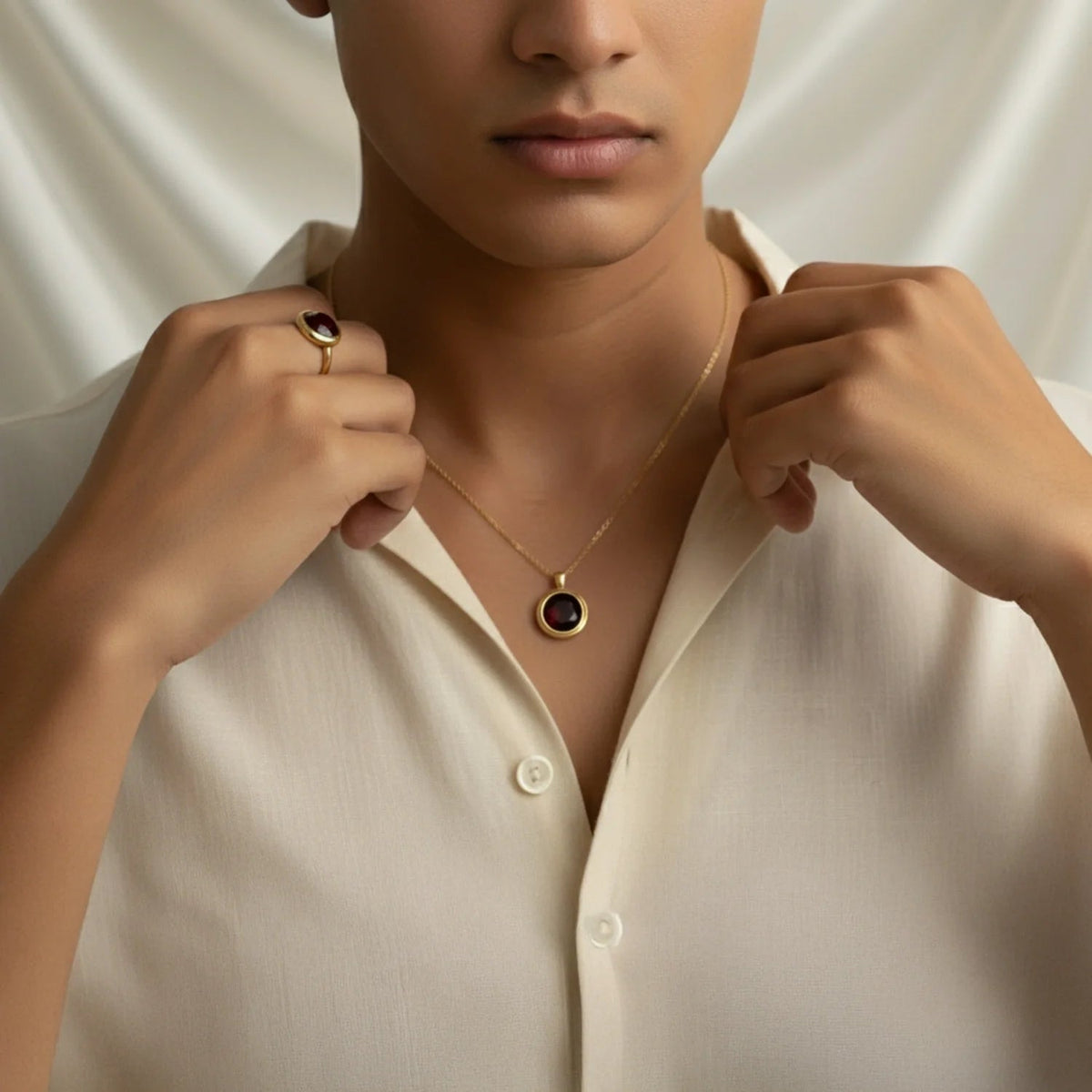 Model wearing a VASTUKOSHA gold necklace and ring featuring deep red natural garnet gemstones against a white backdrop.