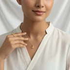 Woman wearing a VASTUKOSHA gold citrine necklace and matching ring against a white backdrop