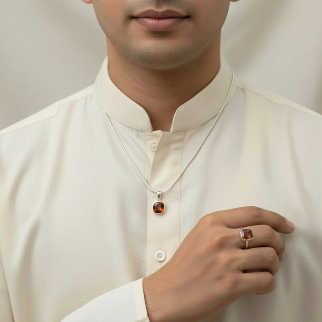 VASTUKOSHA natural hessonite gemstone set in a silver pendant and ring worn by a man in a cream-colored kurta