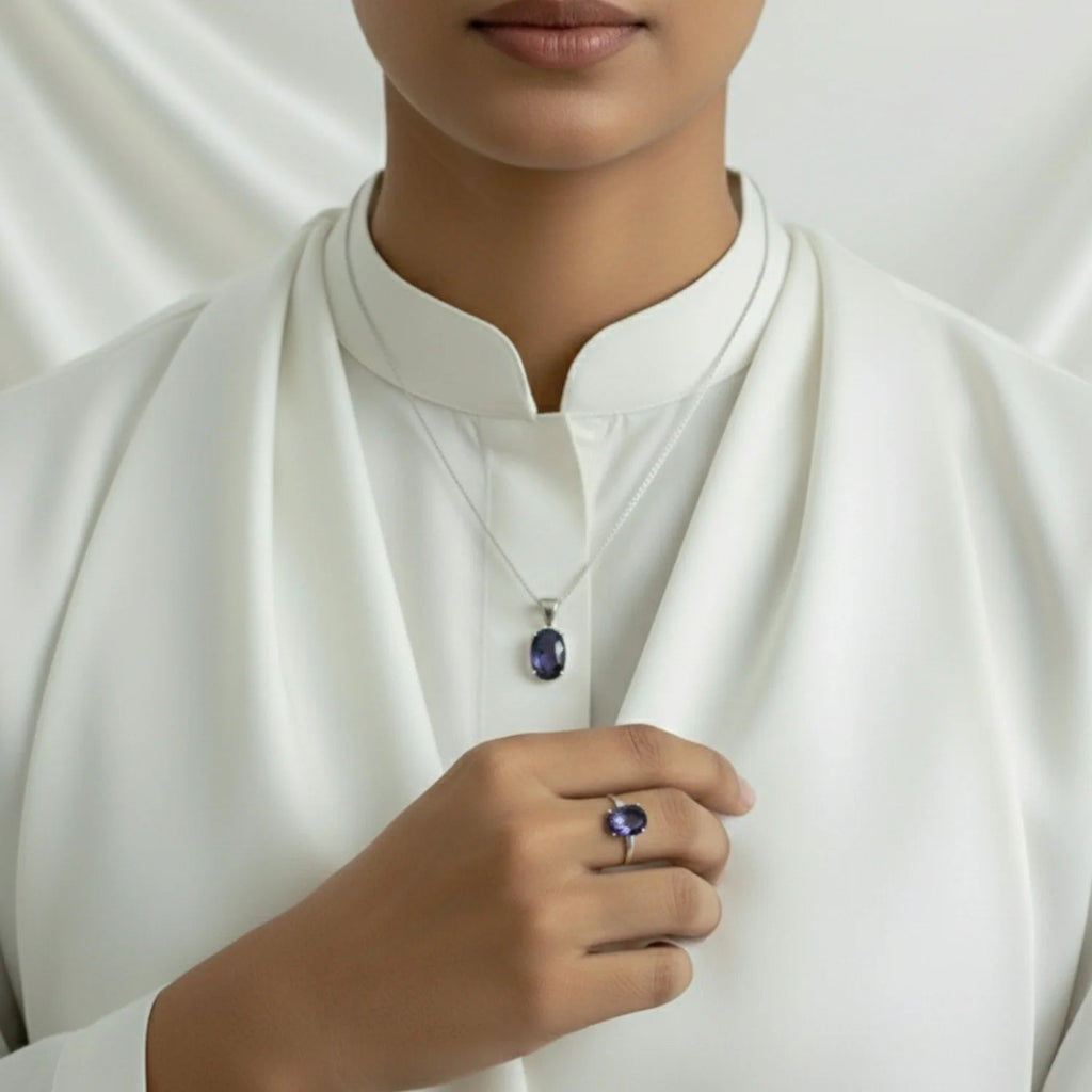VASTUKOSHA Iolite gemstone pendant and matching ring set in silver, worn by a person in a white blouse.