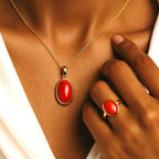 VASTUKOSHA Italian red coral pendant and ring set worn by a woman, featuring polished oval gemstones in gold settings.