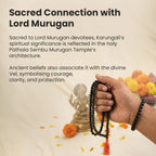 VASTUKOSHA Karungali mala and bracelet set held in hand with Lord Murugan statue in background for spiritual practice