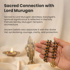 VASTUKOSHA Karungali mala with black ebony beads, gold-plated caps, and a Hanuman Kavach pendant held in a hand.