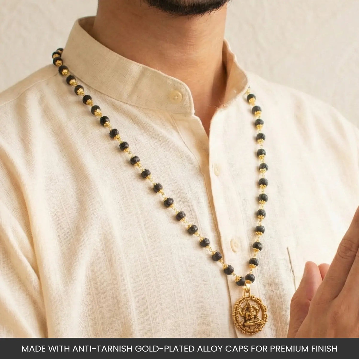 VASTUKOSHA Karungali mala with black ebony beads, gold-plated caps, and a Hanuman Kavach pendant worn by a man.