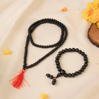 VASTUKOSHA Karungali wood mala and bracelet set with black beads and a red tassel on a cream fabric background.