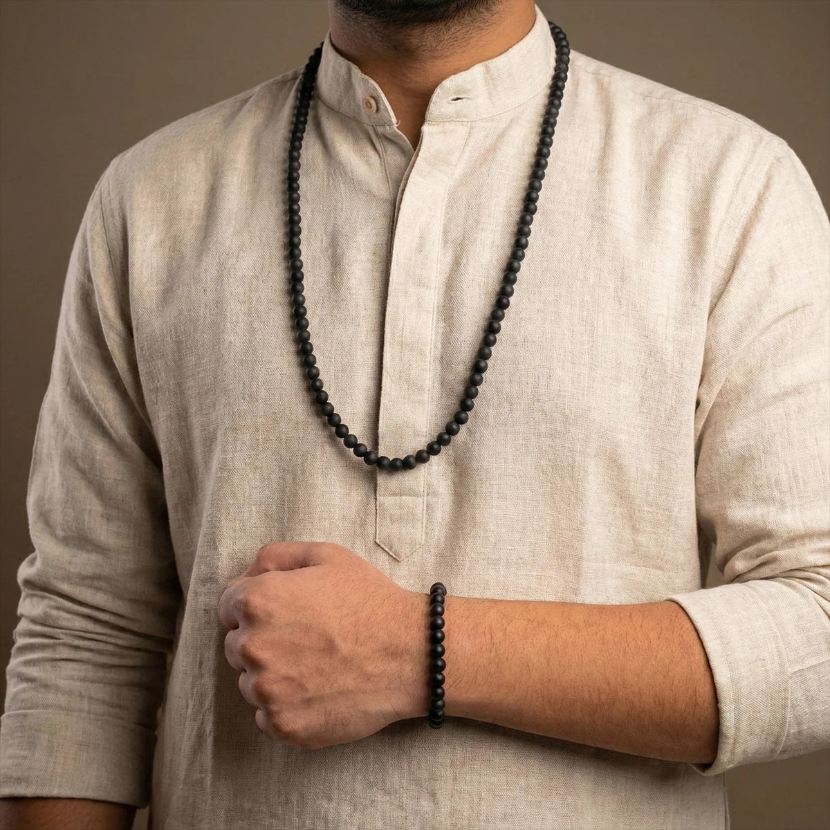VASTUKOSHA Karungali wood mala necklace and matching bracelet set worn by a man in a beige linen kurta