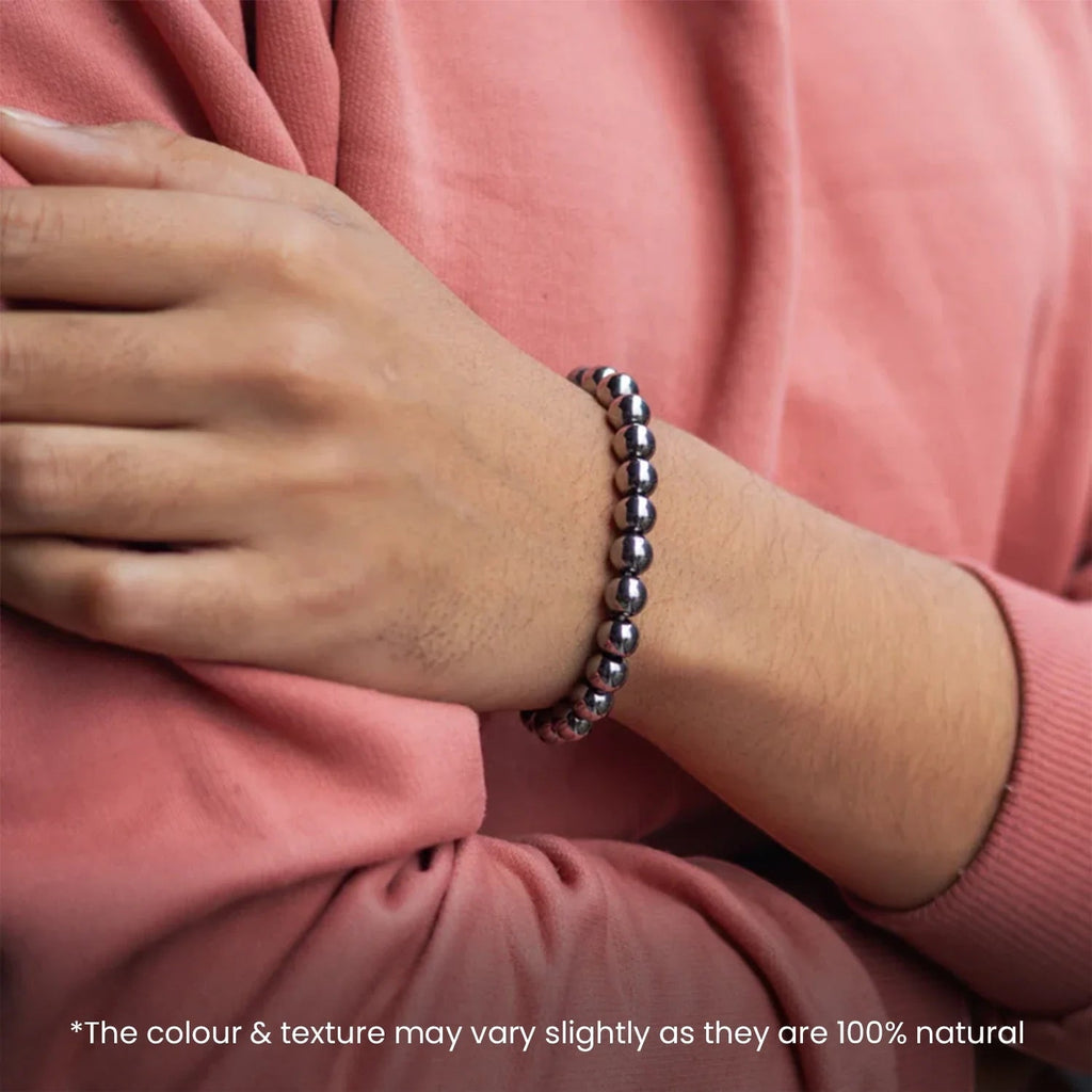 VASTUKOSHA Karz Mukti bracelet made of polished silver hematite beads worn on a wrist with a pink long-sleeve shirt.