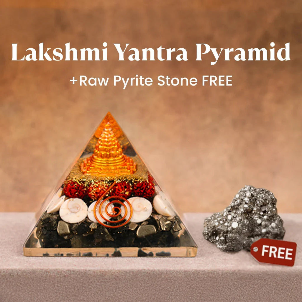 VASTUKOSHA Lakshmi Yantra pyramid with gold accents and seashells alongside a raw metallic pyrite stone for prosperity.