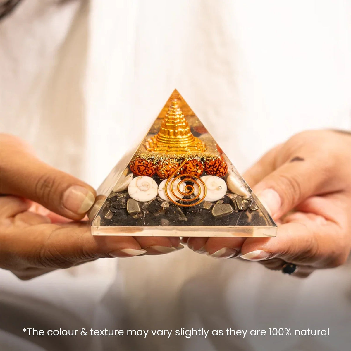 VASTUKOSHA Lakshmi Yantra pyramid with gold-tone symbol, rudraksha beads, and natural stones held in hands