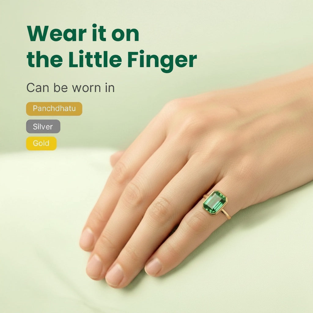 VASTUKOSHA natural emerald ring on a finger, featuring a rectangular green gemstone set in a minimalist gold band.
