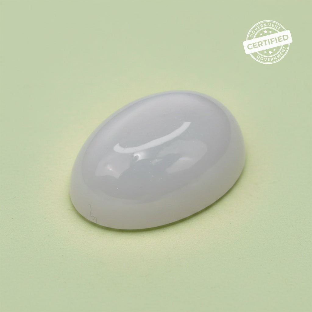 VASTUKOSHA natural oval moonstone gemstone with a smooth polished surface on a light green background