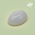 VASTUKOSHA natural oval moonstone gemstone with a smooth polished surface on a light green background