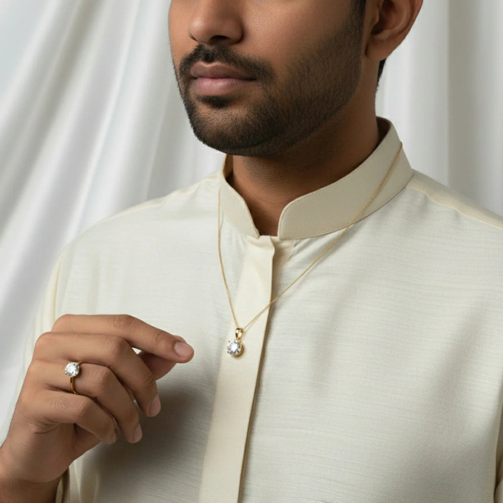 A man wearing a VASTUKOSHA natural zircon ring and pendant set in gold, styled with a traditional cream-colored kurta.
