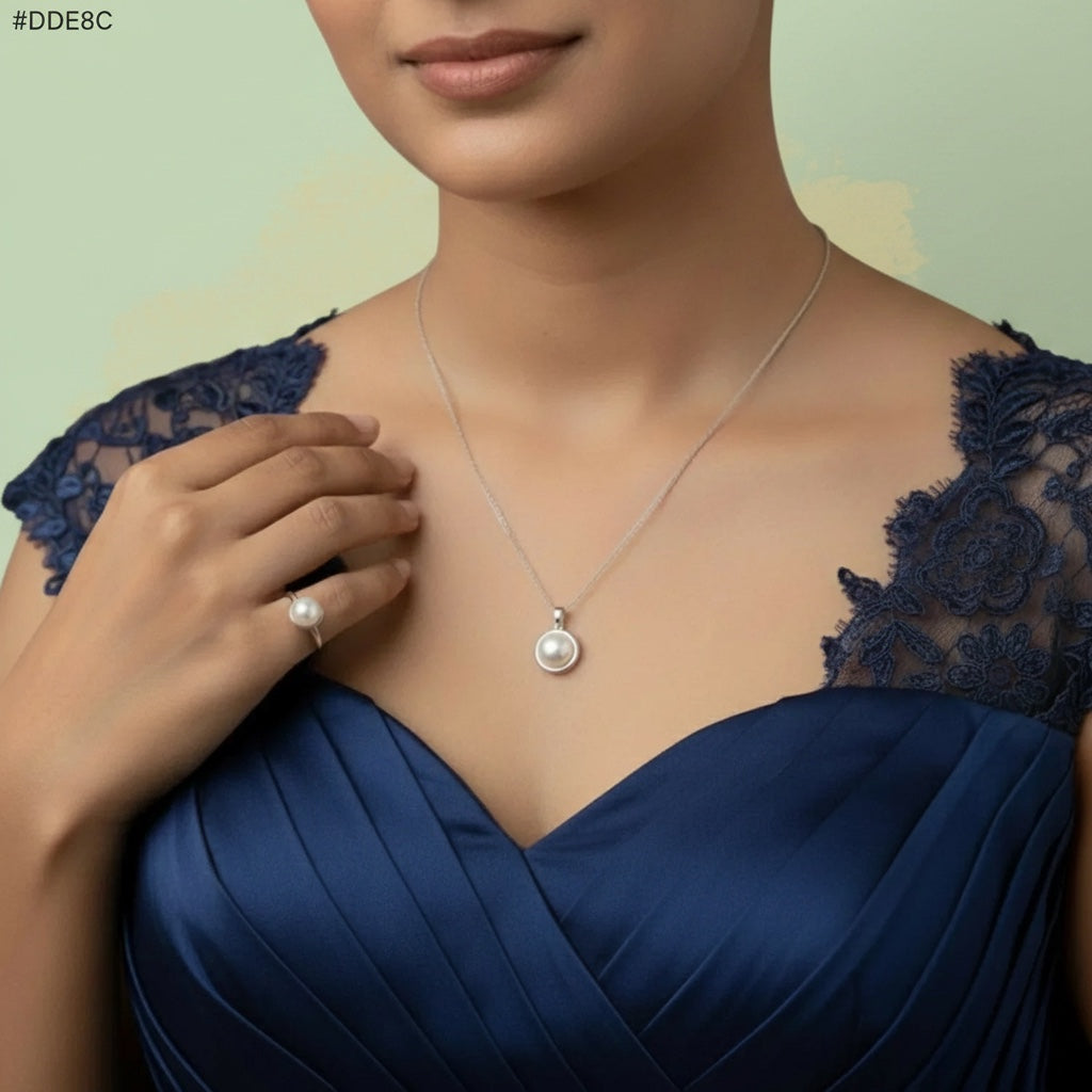 VASTUKOSHA pearl pendant necklace and matching ring worn by a woman in a navy blue dress for spiritual elegance.