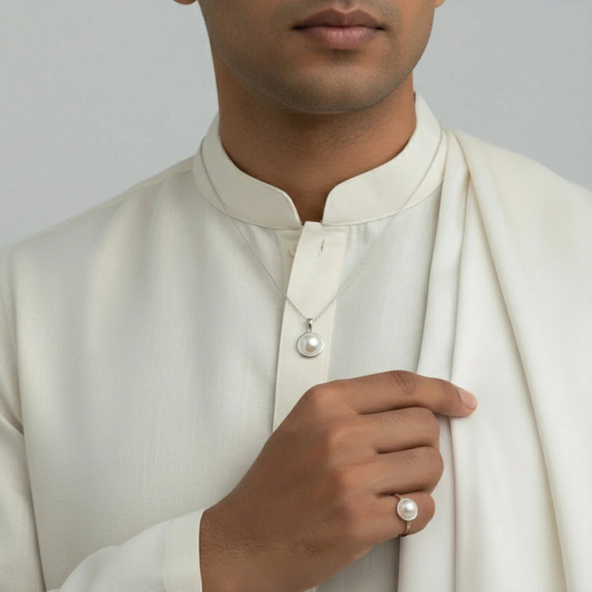 VASTUKOSHA pearl pendant necklace and matching ring worn by a man in a cream-colored traditional kurta