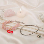 VASTUKOSHA raw pyrite anklet and rose quartz chip bracelet set on white silk fabric with a candle and baby's breath.