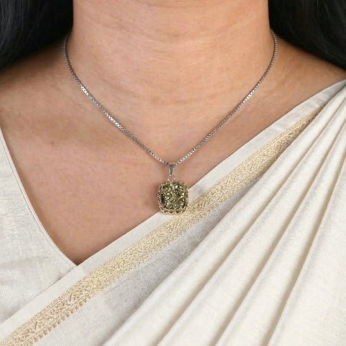 VASTUKOSHA pendant necklace featuring a textured metallic pyrite crystal stone on a silver chain worn with a white saree