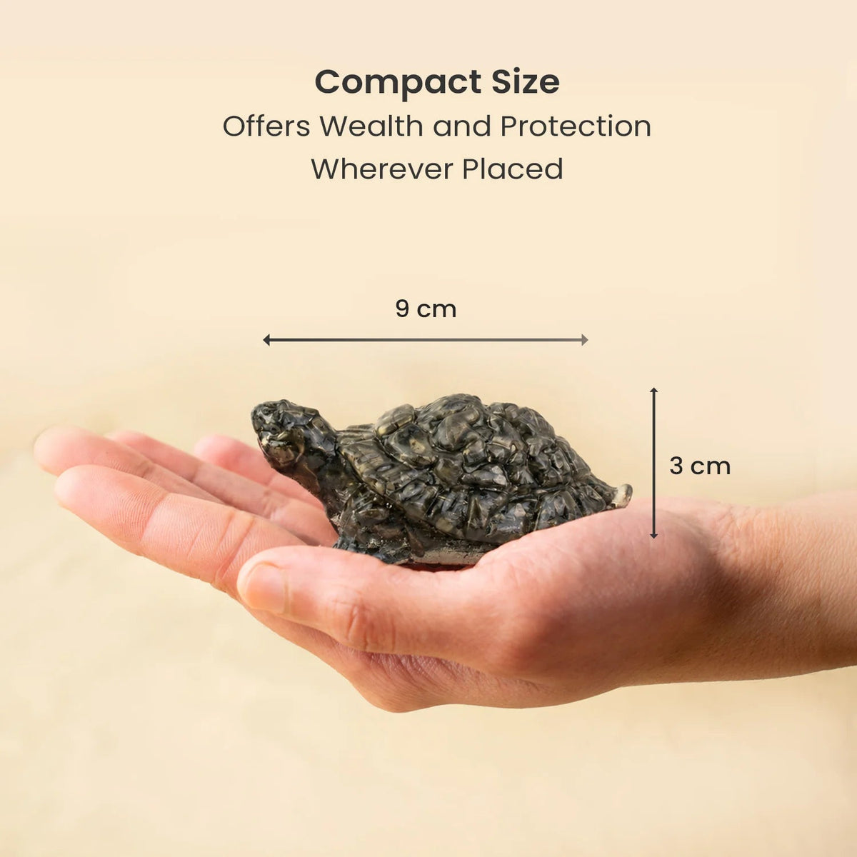 VASTUKOSHA natural pyrite tortoise figurine held in a hand, showing its compact 9cm by 3cm size for Vastu decor.