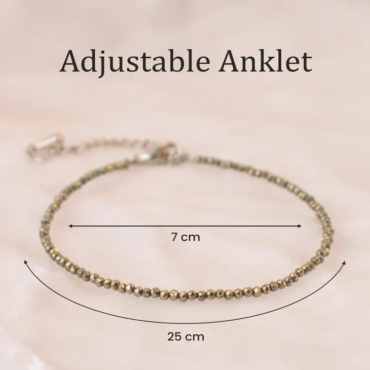 VASTUKOSHA adjustable raw pyrite anklet with metallic gold-toned beads on a soft background, showing 25cm length.