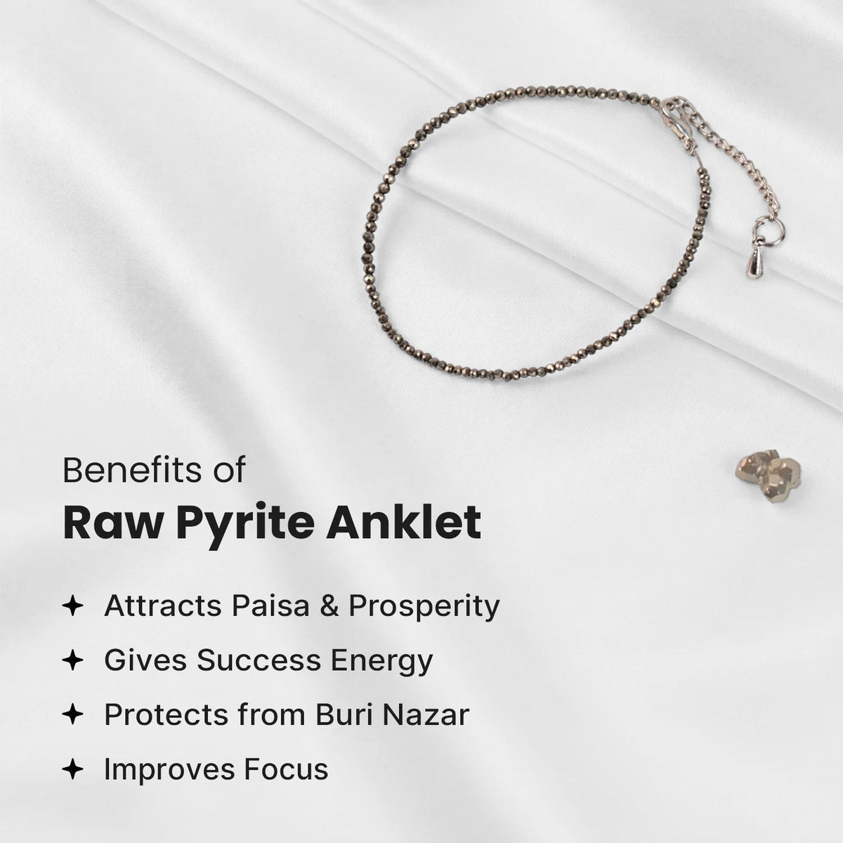 VASTUKOSHA raw pyrite anklet with metallic beads on white fabric, promoting prosperity and focus.