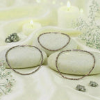 VASTUKOSHA Rishikesh Siddh raw pyrite beaded anklets displayed on smooth stones with candles and white flowers.