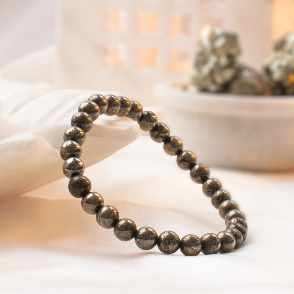 VASTUKOSHA raw pyrite beaded bracelet with metallic 6mm stones on a soft white fabric background
