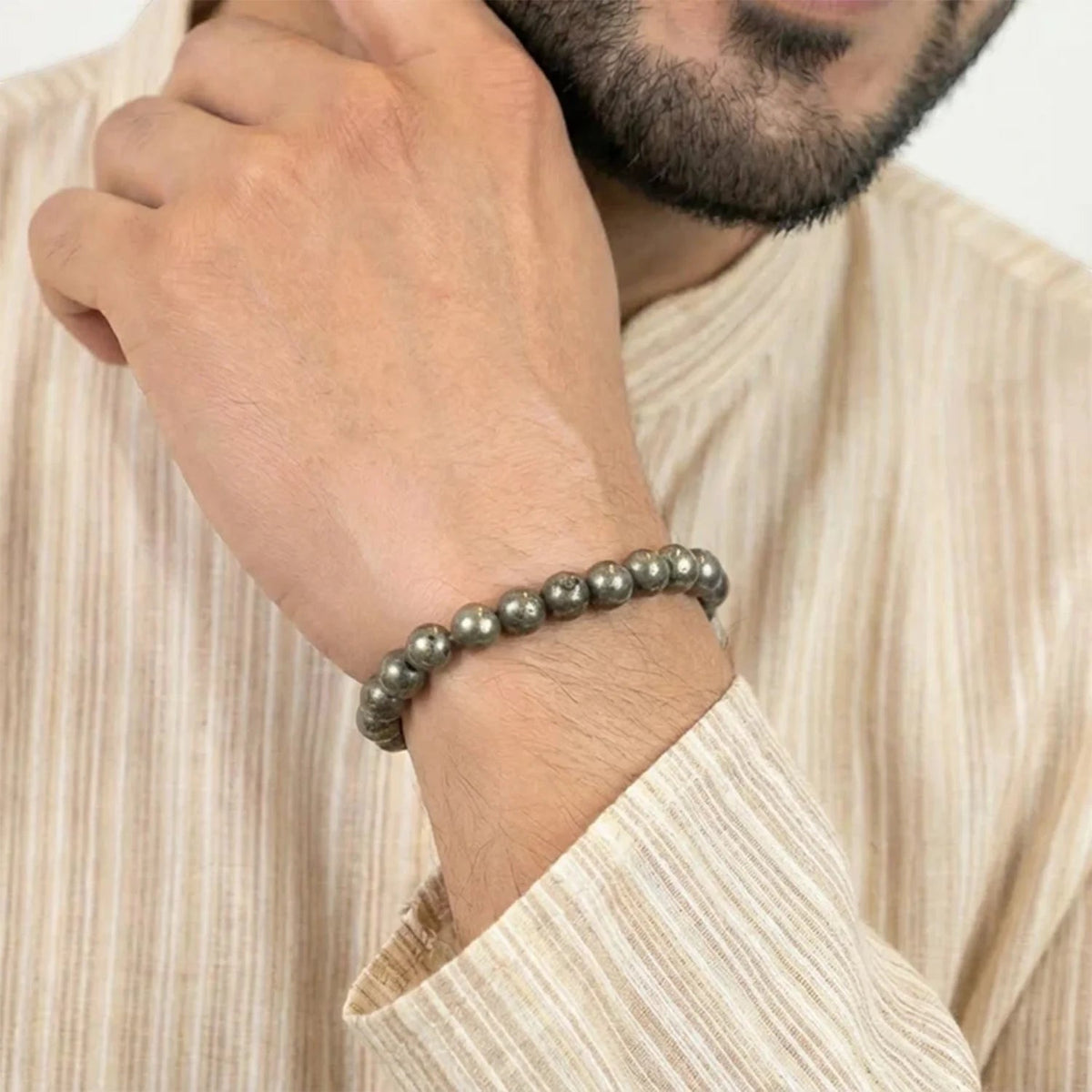 VASTUKOSHA raw pyrite beaded bracelet worn on a man's wrist, featuring metallic grey natural crystal beads.