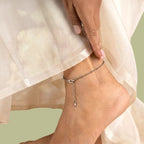 VASTUKOSHA raw pyrite crystal anklet worn on a woman's ankle, featuring metallic stone beads and a delicate chain.