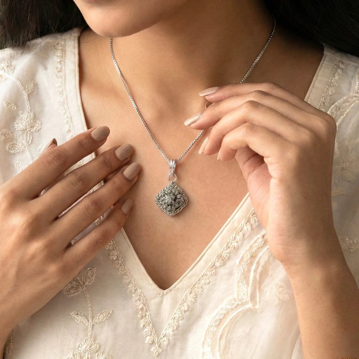 VASTUKOSHA Princess Combo featuring a raw metallic pyrite pendant on a silver chain worn by a woman in a white blouse.