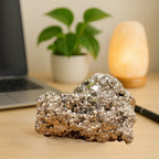 VASTUKOSHA raw pyrite stone with metallic luster on a desk, symbolizing prosperity and abundance for home decor.